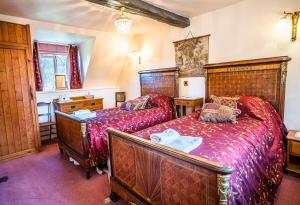 two beds in a bedroom with red sheets at Lower Mill 1 Cottage Broadway in Broadway
