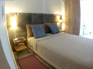 a bedroom with a large bed with blue pillows at LILIUM HOUSE PALEKASTRO in Palekastron