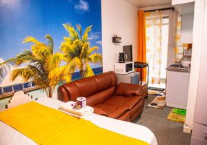 um quarto com uma cama, um sofá e palmeiras em Luxurious studio apartment in Nakuru em Nakuru