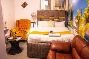 um quarto com uma cama, uma cadeira e um sofá em Luxurious studio apartment in Nakuru em Nakuru