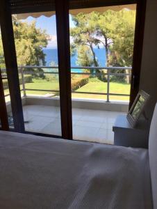 a bedroom with a bed and a view of the ocean at Cute house by the sea in Kriopigi