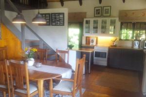 cocina y comedor con mesa y sillas en The Underberg Cottage, en Underberg