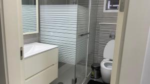 La salle de bains est pourvue d'un lavabo et de toilettes. dans l'établissement 3 bdrm Cityview Apt with Pool, Gym & Children Playground, à Accra