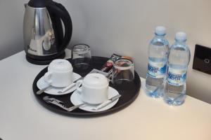 Odessa的住宿－Ultramarinn Hotel，桌子,盘子上装有杯子和瓶装水