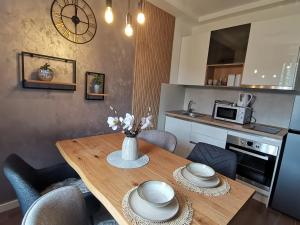 a kitchen with a wooden table with chairs and a microwave at Apartment Novi Park Bulatovic in Vrdnik