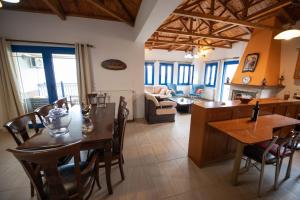 a kitchen and living room with a table and chairs at Panoramic Sea View Villa Evmenia and Harbourside Sea front apartments in Loutraki