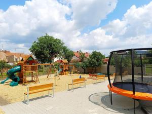 a playground with benches and a slide in a park at Penzion Volařík in Dolní Dunajovice