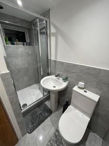 uma casa de banho com um WC, um chuveiro e um lavatório. em BELLACASA GUESTHOUSE em Nottingham
