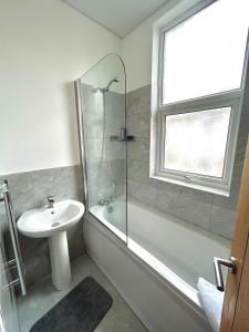 uma casa de banho com um lavatório e uma cabina de duche em vidro. em BELLACASA GUESTHOUSE em Nottingham