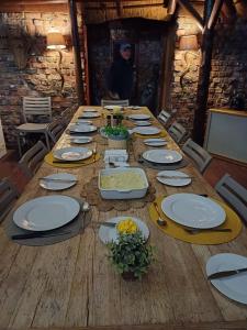uma longa mesa de madeira com pratos e flores em Harmony Luxury Tents & Safari em Addo
