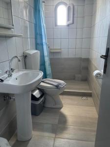 a bathroom with a sink and a toilet and a window at Antiko Apts & Studios in Hersonissos