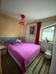 コシチェリスコにあるApartament Różaのベッドルーム(紫色のベッド1台、窓付)