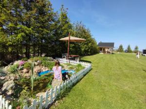 a little girl playing in a sandbox in a garden at Urlopownia-Domki z Indywidulanym Ogrodzeniem-Dogfriendly-Duży,Zielony Teren in Gąski