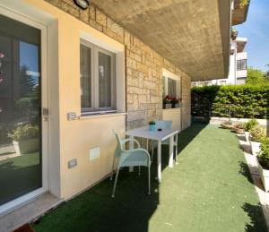 een patio met een tafel en stoelen op het gras bij Miramare casa vacanze in Rimini