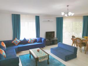 a living room with a blue couch and a table at Manolyam suit havuzlu 2+1 in Kaş