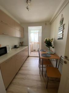 a kitchen with a table and a dining room at Cozy Neversea Apartament in Constanţa