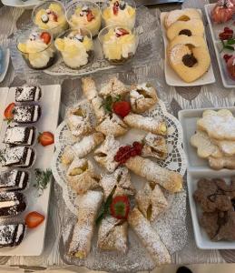 un tavolo con diversi tipi di dessert su piatti di Hotel Villa Paola a Rimini