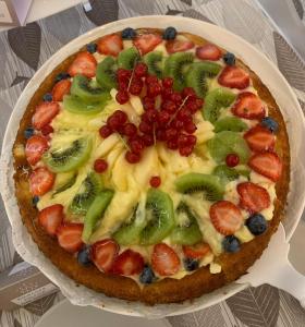 a pizza with fruit on a plate on a table at Hotel Villa Paola in Rimini