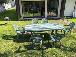 uma mesa de piquenique e cadeiras com uma mesa e uma mesa e cadeiras em Maison récente à 15 minutes de la plage em Dinard