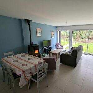 uma sala de estar com um sofá, uma mesa e uma lareira em Maison récente à 15 minutes de la plage em Dinard