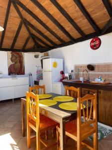 a kitchen with a table and chairs and a kitchen with a refrigerator at La Puerta del Sol in Adeje