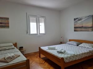 1 dormitorio con 2 camas y ventana en Riva Del Mare, en Bijela