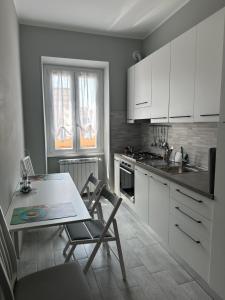 羅馬的住宿－Casa Saida，厨房配有白色橱柜和桌椅