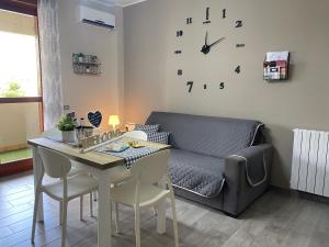a living room with a table and a couch at Casa vacanze “Dolce sosta” in Quartu SantʼElena