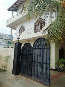 una casa con un cancello nero davanti di Athena Guest House a Trincomalee
