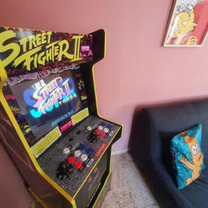 una máquina de videojuegos en una habitación junto a un sofá en Gîte Aventure, logement entier + escape game !, en Verzenay