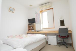 Habitación con cama, escritorio y silla. en Hotel Nishi In Fujisan, en Fuji