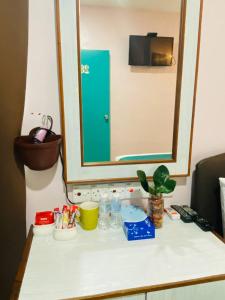 a counter top with a mirror and bottles on it at Sun Tree Hotel in Kampong Kerayong