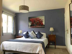 een slaapkamer met een groot bed met blauwe muren bij Riverside Lodge in Chablis
