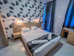 Un dormitorio con una cama grande y una pared con aiger en Rilena Hotel en Kiten