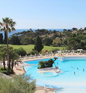 a large swimming pool at a resort with people in it at Magic mer in Saint-Raphaël