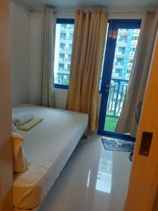 ein kleines Schlafzimmer mit einem Bett und einem Fenster in der Unterkunft Sea residence reyplace in Manila