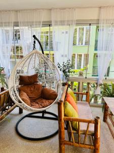 um quarto com um baloiço de vime com almofadas em Karakum hotel em Ureki