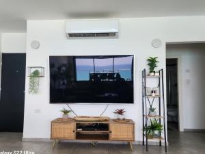 a living room with a large tv on a wall at The Kingdom On The Beach in Bat Yam