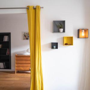 a yellow curtain in a room with a shelf at Maison Cimes in Les Orres