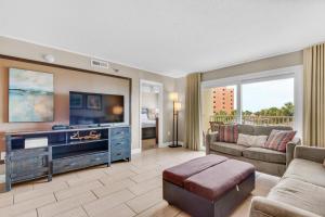 a living room with a couch and a tv at The Islander 214 in Destin