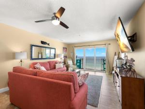 ein Wohnzimmer mit einem roten Sofa und Meerblick in der Unterkunft Sea Breeze 708 in St Pete Beach