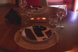 una mesa de madera con dos platos y copas de vino en Agriturismo Albarosa-Terre dell'Amore, en Marina di Grosseto