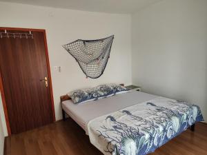 a bedroom with a bed and a net hanging on the wall at Apartman Olja in Pag