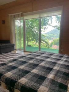 sypialnia z łóżkiem szachowym i dużym oknem w obiekcie Хижа Гора w mieście Szajan