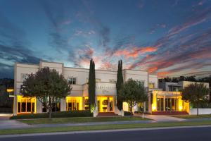 a large white building with a sunset in the sky at The Carrington Hotel in Shepparton