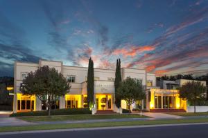 un grand bâtiment blanc avec un coucher de soleil dans le ciel dans l'établissement The Carrington Hotel, à Shepparton