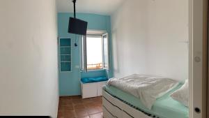 een kleine slaapkamer met een bed en een raam bij Sole Vista Mare 999 in LʼAmericano