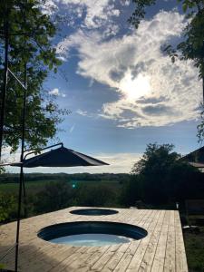 a patio with an umbrella and a small pool at Cabane Bivouac avec échelle à l'ombre des chênes in Idrac-Respailles