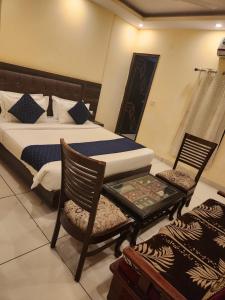 a bedroom with a bed and two chairs and a table at Hotel City Lite Near IGI Airport Delhi in New Delhi