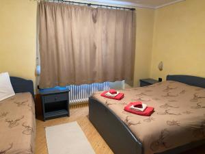 een slaapkamer met een bed met rode slippers erop bij Baita Brozol in Livigno